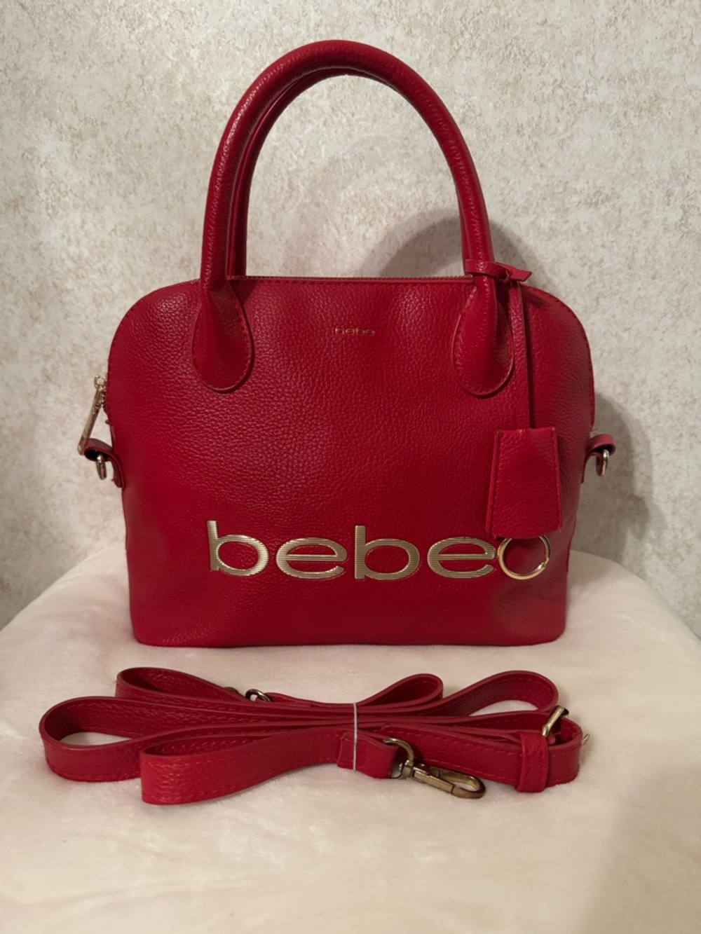 bebe Red Pebbled Leather Satchel with Gold Logo Accent with strap.
